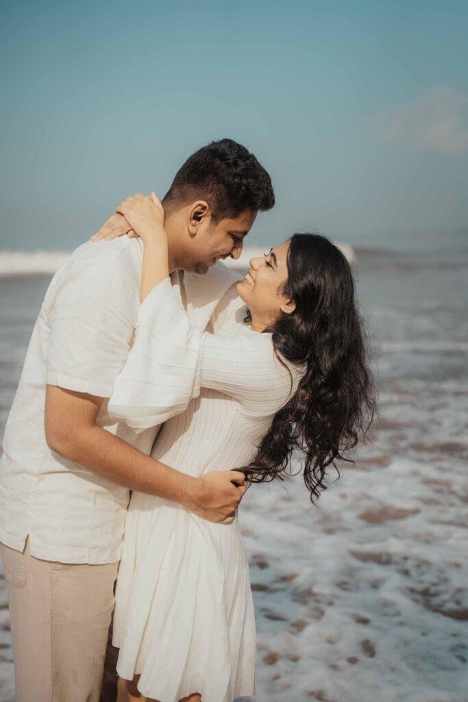A couple trending posing during a pre-wedding photoshoot on Goa beach with a golden sunset in the background.