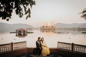 Couple posing in traditional outfits during a pre wedding shoot at Jal Mahal Jaipur